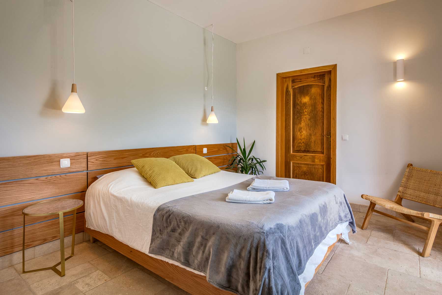a bed with a blanket and a wooden headboard