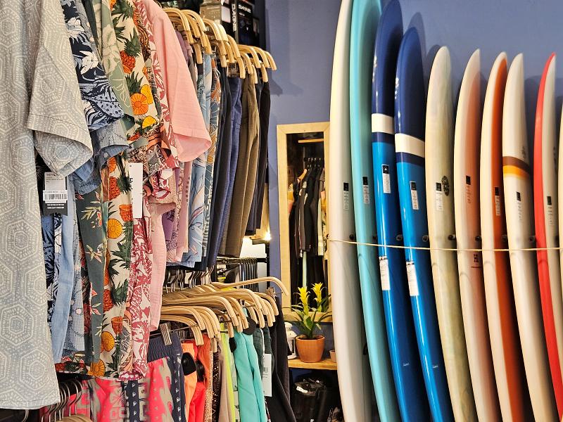 a grove of surfboards are lined up in a rack in a store